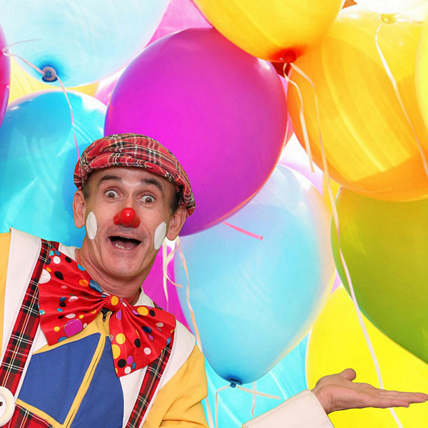 Clown vor Luftballonmasse.